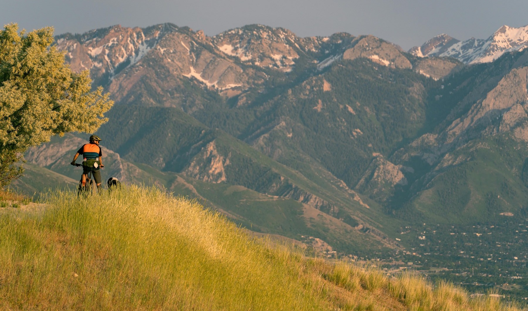 a person riding a bike with mountains in the distance
